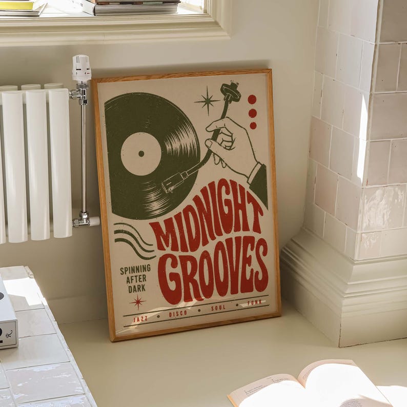 May include: A framed rectangular poster with a cream background featuring a green vinyl record and a hand operating a turntable tonearm. The text reads MIDNIGHT GROOVES, SPINNING AFTER DARK, JAZZ, DISCO, SOUL, and FUNK in red and black lettering.