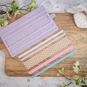 May include: A purple silicone mold with six different braid designs. The mold is on a wooden cutting board with several finished braids in different colors.