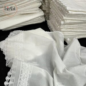 Puede incluir: Una pila de pa&ntilde;uelos de algod&oacute;n blanco con ribete de encaje. Los pa&ntilde;uelos est&aacute;n doblados y apilados cuidadosamente. Los pa&ntilde;uelos est&aacute;n hechos de una tela suave y delicada.