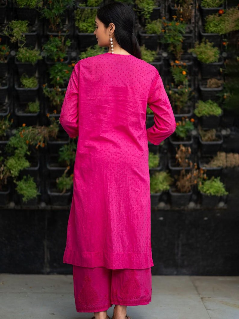 May include: A pink kurta and palazzo set with a dotted pattern. The kurta has long sleeves and a round neckline. The palazzo pants are wide-legged and flowy.