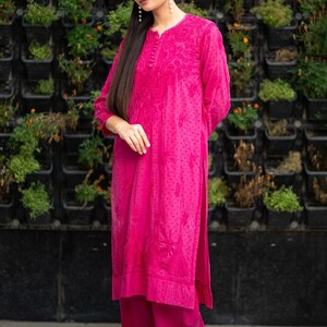 May include: A pink long-sleeved kurta with floral embroidery and a matching pair of palazzo pants. The kurta has a button-up neckline and a slightly flared silhouette. The palazzo pants have a wide leg and a comfortable fit.