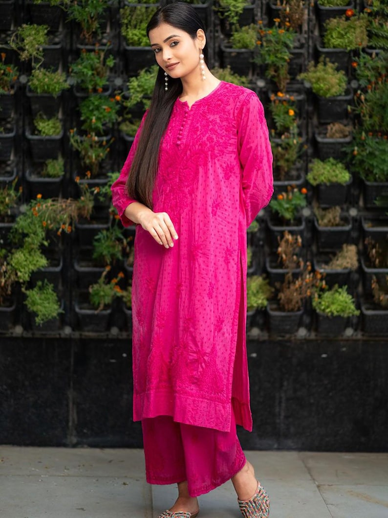 May include: A pink long-sleeved kurta with floral embroidery and a matching pair of palazzo pants. The kurta has a button-up neckline and a slightly flared silhouette. The palazzo pants have a wide leg and a comfortable fit.
