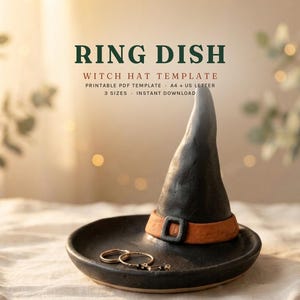 Może przedstawiać: Czarna podstawka na pierścionki z wyrzeźbionym kapeluszem czarownicy z pomarańczową opaską i klamrą. Tekst głosi: RING DISH, WITCH HAT TEMPLATE, PRINTABLE PDF TEMPLATE, A4 + US LETTER, 3 SIZES, INSTANT DOWNLOAD. Na podstawce leżą dwa złote pierścionki.