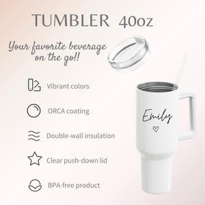 May include: White 40oz tumbler with a handle, lid, and straw. The tumbler has the name "Emily" and a heart symbol printed on it. Features include vibrant colors, ORCA coating, double-wall insulation, a clear push-down lid, and is BPA-free.