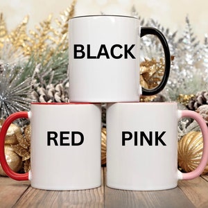 May include: Three ceramic mugs with black handles. The mugs are white with black lettering. The mugs say "BLACK", "RED", and "PINK".