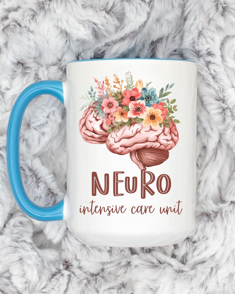 May include: White ceramic mug with a blue handle and rim. The mug features a brain illustration adorned with colorful flowers. The words "NEURO intensive care unit" are printed in brown.