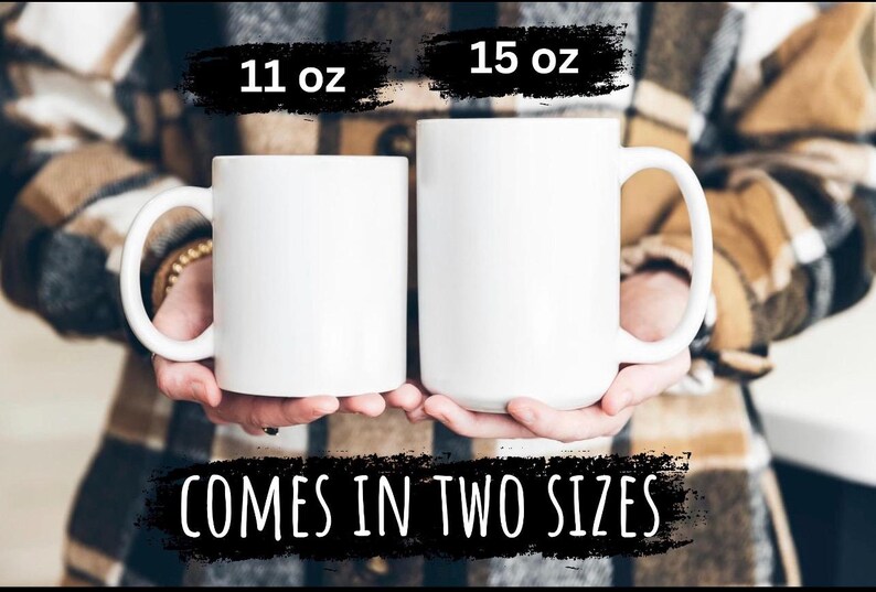 May include: Two white ceramic mugs, one 11 oz and one 15 oz, are held in front of a person. The mugs have large handles. The text "COMES IN TWO SIZES" is displayed below the mugs.