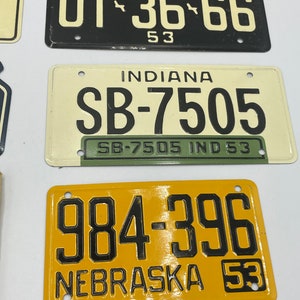 May include: Three vintage license plates from Michigan, Indiana, and Nebraska. The Michigan plate is black with white lettering and reads "UT-36-66". The Indiana plate is cream with black lettering and reads "SB-7505". The Nebraska plate is yellow with black lettering and reads "984-396".