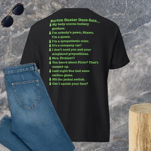 May include: A black short-sleeved t-shirt featuring bright green text that reads: Burton Guster Once Said... followed by a list of quotes including My body craves buttery goodnes, I'm nobody's pawn, Shawn, I'm a queen, and Can I squish your face?
