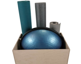 May include: A beige wooden storage box with a blue exercise ball, a teal yoga mat, a gray yoga mat, and a rolled-up gray yoga mat inside.