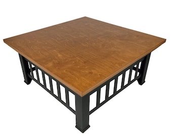 May include: Square wooden coffee table with a light brown top and black legs. The table has a modern design with a slatted side detail. The table is approximately 36 inches wide and 18 inches tall.