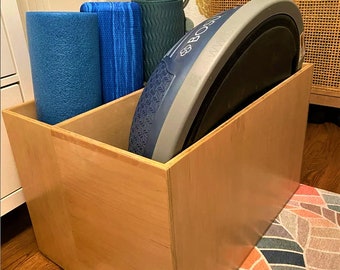 May include: A wooden storage box with a blue and gray BOSU ball and three blue yoga mats inside.
