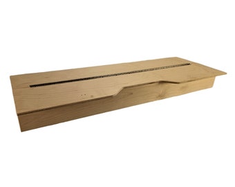 May include: A wooden box with a hinged lid and a slot in the top. The box is made of light-colored wood and has a natural finish.