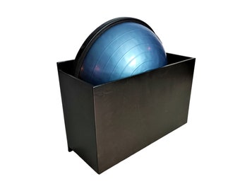 May include: A black storage box with a blue exercise ball inside. The box is made of metal and has a rectangular shape.