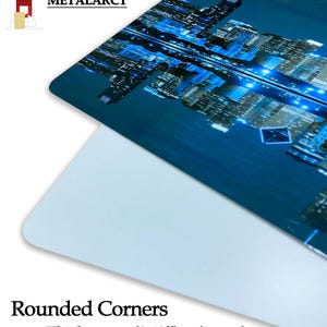 Puede incluir: Una impresi&oacute;n met&aacute;lica azul con una ciudad nocturna. La impresi&oacute;n tiene esquinas redondeadas y un grosor de aproximadamente 10 mm.