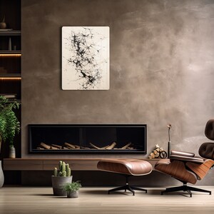 Puede incluir: Una sala de estar moderna con una chimenea, un sill&oacute;n y un reposapi&eacute;s de cuero marr&oacute;n, una planta en maceta y una pintura abstracta en blanco y negro en la pared.