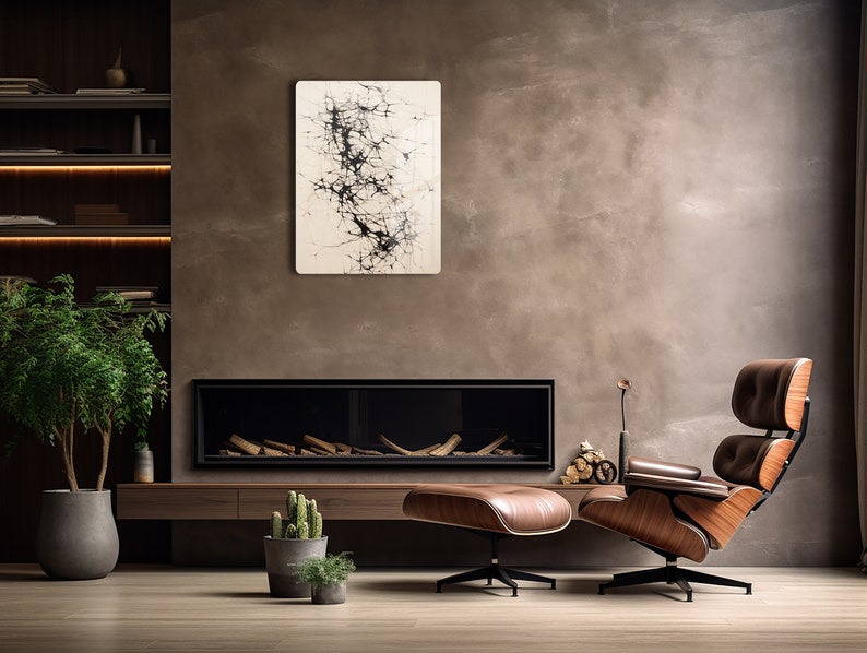 Puede incluir: Una sala de estar moderna con una chimenea, un sill&oacute;n y un reposapi&eacute;s de cuero marr&oacute;n, una planta en maceta y una pintura abstracta en blanco y negro en la pared.