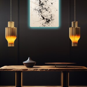Puede incluir: Una mesa de madera con una tapa de borde vivo y patas de metal. Un jarr&oacute;n negro y una bandeja redonda de madera est&aacute;n sobre la mesa. Una pintura abstracta en blanco y negro cuelga de la pared detr&aacute;s de la mesa. Dos l&aacute;mparas colgantes doradas cuelgan sobre la mesa.