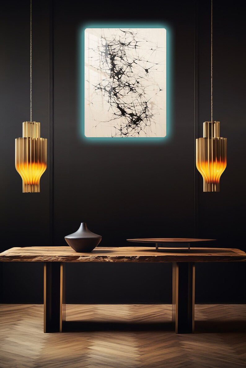 Puede incluir: Una mesa de madera con una tapa de borde vivo y patas de metal. Un jarr&oacute;n negro y una bandeja redonda de madera est&aacute;n sobre la mesa. Una pintura abstracta en blanco y negro cuelga de la pared detr&aacute;s de la mesa. Dos l&aacute;mparas colgantes doradas cuelgan sobre la mesa.