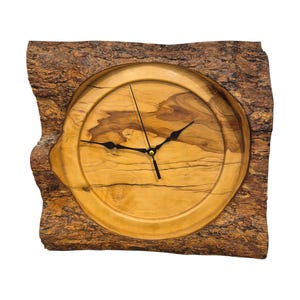 May include: A square wooden clock with a natural bark frame. The clock face is a light wood color with black hands and a gold-colored center. The bark frame is a dark brown color.