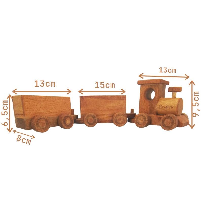 May include: A wooden toy train with three connected cars. The engine has a circular window and the name "Brian" engraved on the side. The train cars are 13 cm, 15 cm, and 13 cm long, and the engine is 9.5 cm tall. The train is made of light brown wood.