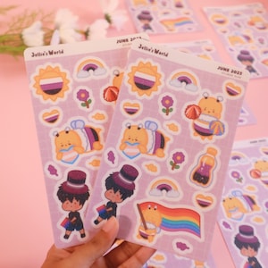 Peut inclure: Deux feuilles d'autocollants avec un fond violet et divers motifs. Les autocollants représentent un arc-en-ciel, un soleil avec une bande noire, blanche et violette, une abeille avec un cœur, une abeille avec un drapeau arc-en-ciel, une personne avec un chapeau haut de forme et une bouteille de liquide. Le texte sur les feuilles indique "Jellie's World" et "June 2023 Sticker Club".