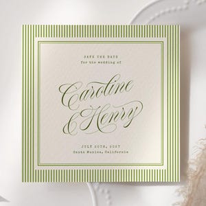 Könnte beinhalten: Quadratische Hochzeitseinladung mit grün gestreiftem Rand und eleganter Schrift, die "Caroline & Henry" lautet. Die Einladung liegt auf einem weißen Teller mit beigem Stoff und Eukalyptusblättern.