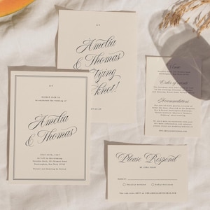 Puede incluir: Un conjunto de tarjetas de invitación de boda color crema con elegante caligrafía negra. Las tarjetas incluyen los nombres "Amelia & Thomas", la frase "Tying Knot!" y otros detalles. Una rodaja de papaya y una copa también están en la imagen.