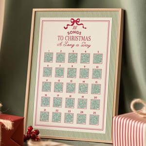 May include: A framed print with the text "25 Songs to Christmas A Song a Day." The print has a cream background with a red and green border and 25 numbered squares. Presents are in the foreground, creating a festive scene.
