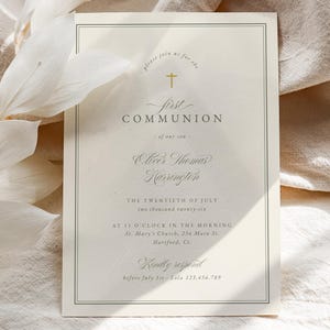 Peut inclure: Invitation de Première Communion crème avec une écriture élégante et une croix dorée. Le texte comprend le nom 'Oliver Thomas Harrington' et la date 'Le vingt juillet'. L'invitation est encadrée d'une fine bordure vert foncé.
