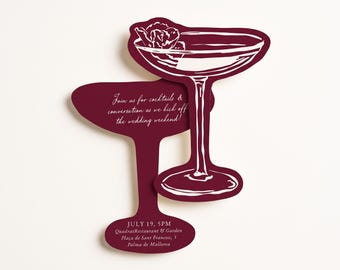 Könnte beinhalten: Eine gestanzte Einladungskarte in Form von zwei überlappenden Cocktailgläsern in tiefem Burgunderrot mit weißen Linien. Der Text lautet: Join us for cocktails & conversation as we kick off the wedding weekend! JULY 19, 5PM Quadrat Restaurant & Garden, Plaça de Sant Francesc, 5, Palma de Mallorca.