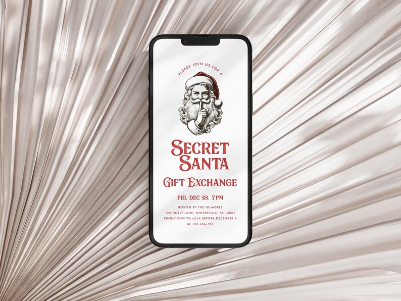 May include: A smartphone screen displaying a digital invitation for a Secret Santa gift exchange. The invitation features a cartoon image of Santa Claus with a finger to his lips, and the text "Secret Santa Gift Exchange" in red lettering. The event is scheduled for Friday, December 18th at 7pm, hosted by the Gilmores at Tex Holly Lane, Winterville, GA 14887. The invitation instructs guests to RSVP to Lola before December 1st at 123-456-7890.