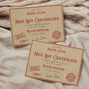 May include: Two brown paper certificates with red borders and red text. The certificates are for "Nice List Certificate" and are from "Santa Claus". The certificates are for "Oliver Spencer" and state that the list has been "checked twice".