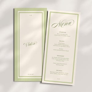 May include: Two cream-coloured menu cards with green borders. One card features the name "Valerie" in cursive, the other displays the word "Menu" in cursive. The menu lists starters, mains, desserts, and drinks.