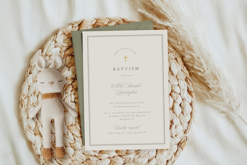 May include: A baptism invitation with a gold cross and elegant font, placed on a woven placemat with a stuffed bunny. The invitation includes the text "Baptism" and event details. A sage green envelope is behind the invitation.