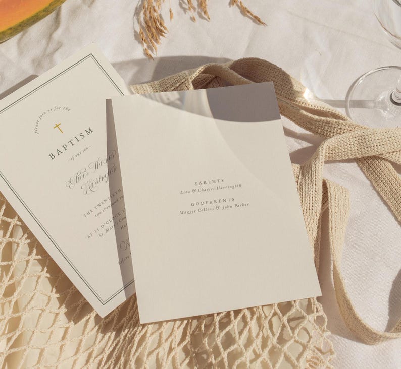 May include: Two off-white baptism invitations with gold text and a cross graphic. One invitation is open, revealing the text "Parents" and "Godparents." The other invitation is closed, with the word "Baptism" visible.