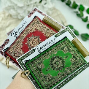 Three favor sets are shown, featuring mini wallets in red, green, and beige patterns, each with a henna tube and a personalized card.
