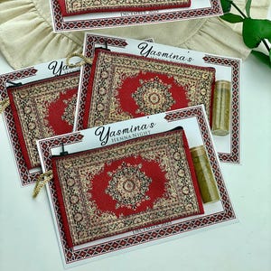 Four red patterned mini wallet favor sets are shown, each with a henna tube and a personalized card.