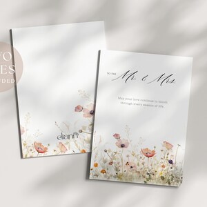 Op de afbeelding: Twee witte wenskaarten met bloemenillustraties. Eén kaart leest "To the Mr. & Mrs." met een bericht eronder. De andere kaart heeft een bloemenontwerp en de merknaam "eliann". Een cirkelvormige afbeelding zegt "TWO SIZES INCLUDED".