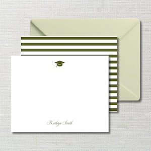 May include: A white stationery card with a dark olive green graduation cap icon at the top center and the name Kathryn Smith printed in a script font at the bottom, paired with a matching envelope featuring dark olive green horizontal stripes.