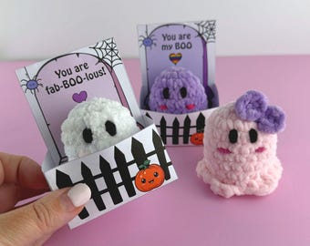 Puede incluir: Tres figuras de fantasmas de ganchillo con temática de Halloween. Un fantasma blanco está en una caja de valla de piquetes en blanco y negro con el texto "You are fab-BOO-lous!". Un fantasma morado está en una caja similar con el texto "You are my BOO". También hay un fantasma rosa con un lazo morado.