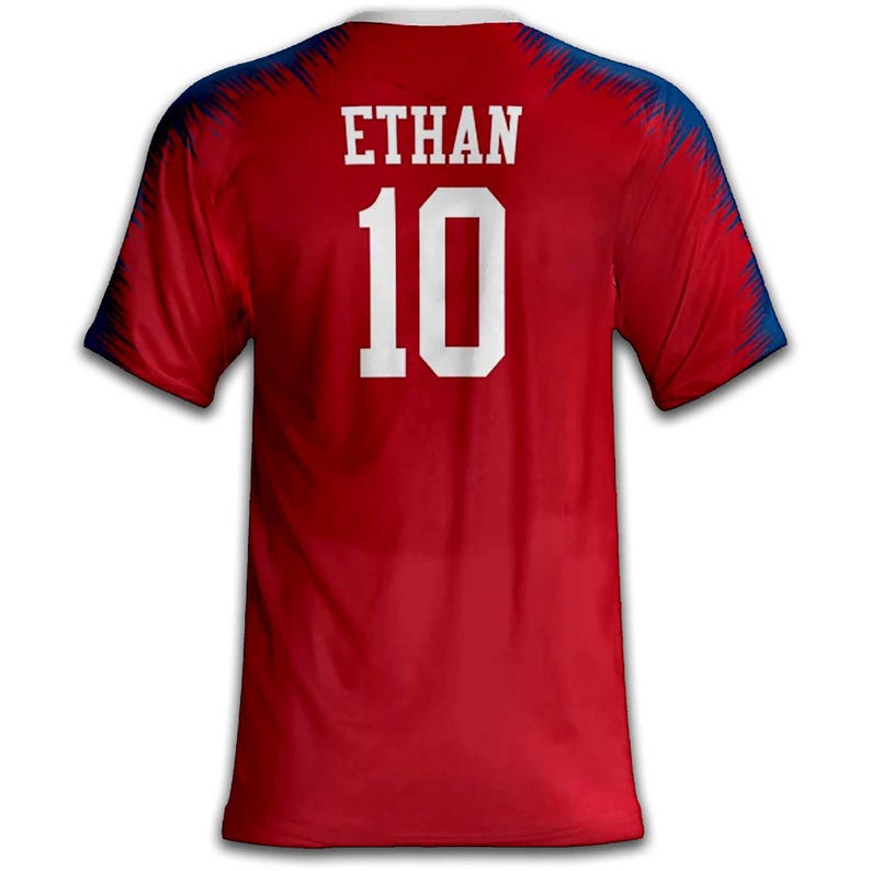 May include: Red athletic jersey with the name "ETHAN" and the number "10" in white block letters. The jersey has a white collar and blue accents on the shoulders.