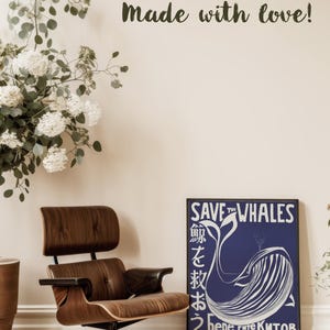 May include: A blue and white poster with the text "Save the Whales" in white lettering. The poster features a stylized illustration of a whale with the text "Берегите китов" in Cyrillic script. The poster is framed and hanging on a wall.