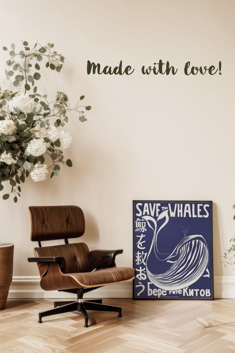 May include: A blue and white poster with the text "Save the Whales" in white lettering. The poster features a stylized illustration of a whale with the text "Берегите китов" in Cyrillic script. The poster is framed and hanging on a wall.