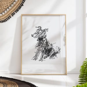 Puede incluir: Una impresión artística enmarcada con un dibujo abstracto en blanco y negro de un perro. La obra de arte está sobre un fondo blanco y enmarcada en un marco de madera clara. El perro parece estar sentado.