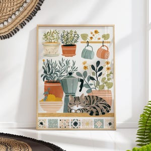 May include: A framed art print depicting a kitchen scene with potted plants, a coffee maker, and a sleeping tabby cat. The artwork uses a soft colour palette of earth tones and pastels, creating a warm and inviting atmosphere for the viewer.