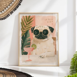 May include: Framed art print of a pug wearing sunglasses, with a cocktail and lime. The illustration has a tropical theme with palm leaves and the text "LA DOLCE VITA". The colour palette includes pink, green, and beige.