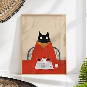 Puede incluir: Lámina artística enmarcada que representa un gato negro con un abrigo rojo y un suéter amarillo, sentado en una mesa roja. Una taza de café, un periódico y un vaso de agua están sobre la mesa. El gato está en una silla azul sobre un fondo beige.