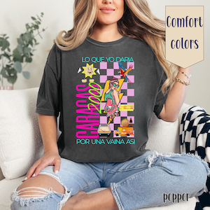 Può includere: Una maglietta grigia scura con una stampa grafica di una donna su pattini a rotelle, un sole, un pappagallo e il testo "CARACAS 2000" e "LO QUE YO DARÍA POR UNA VAINA ASÍ".