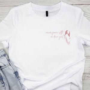 May include: White t-shirt with a pink graphic of a woman with the text "never gonna settle on down girl!"
